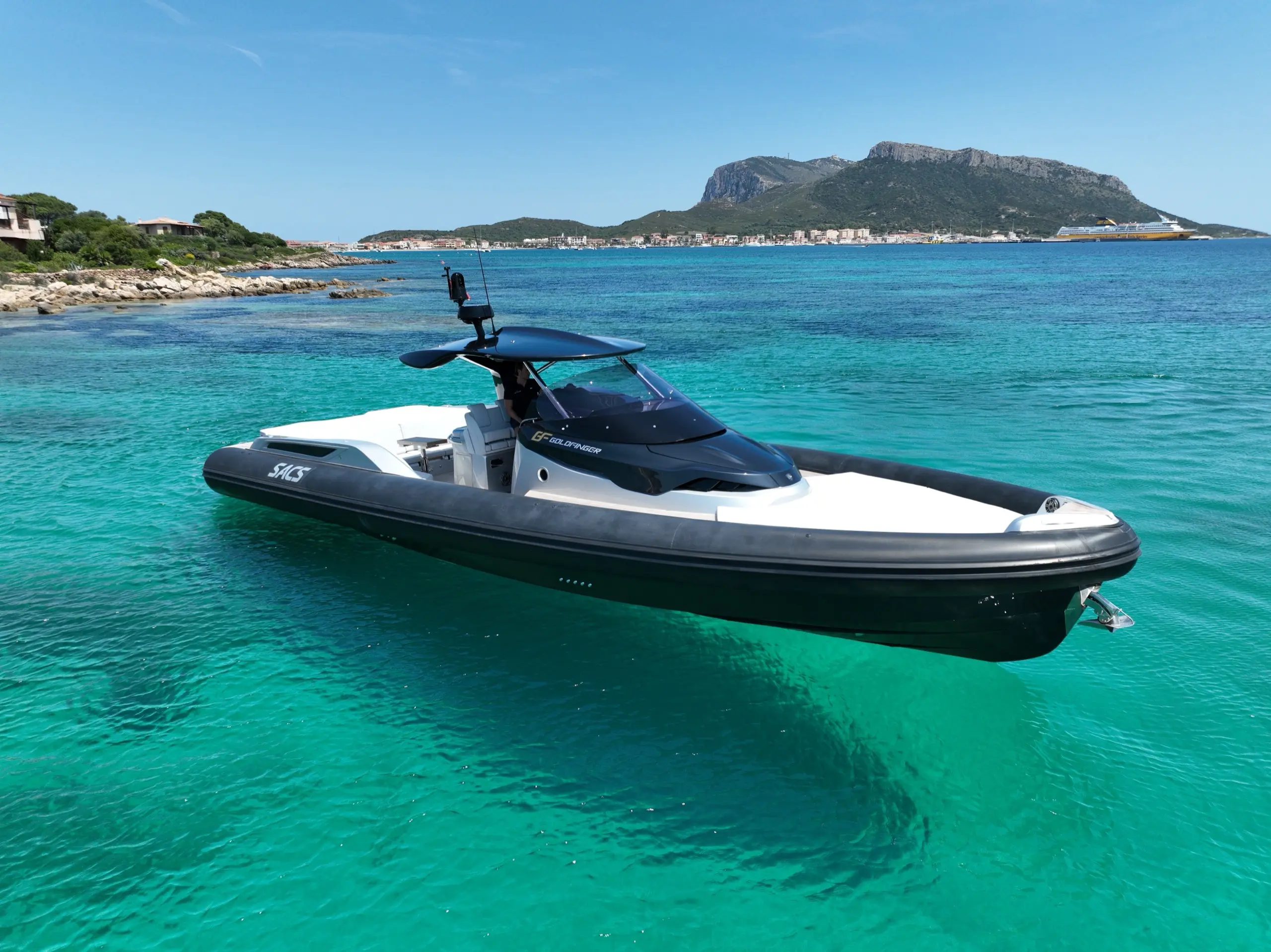 SACS Strider 15 anchored in shallow turquoise bay with Tavolara island in the background