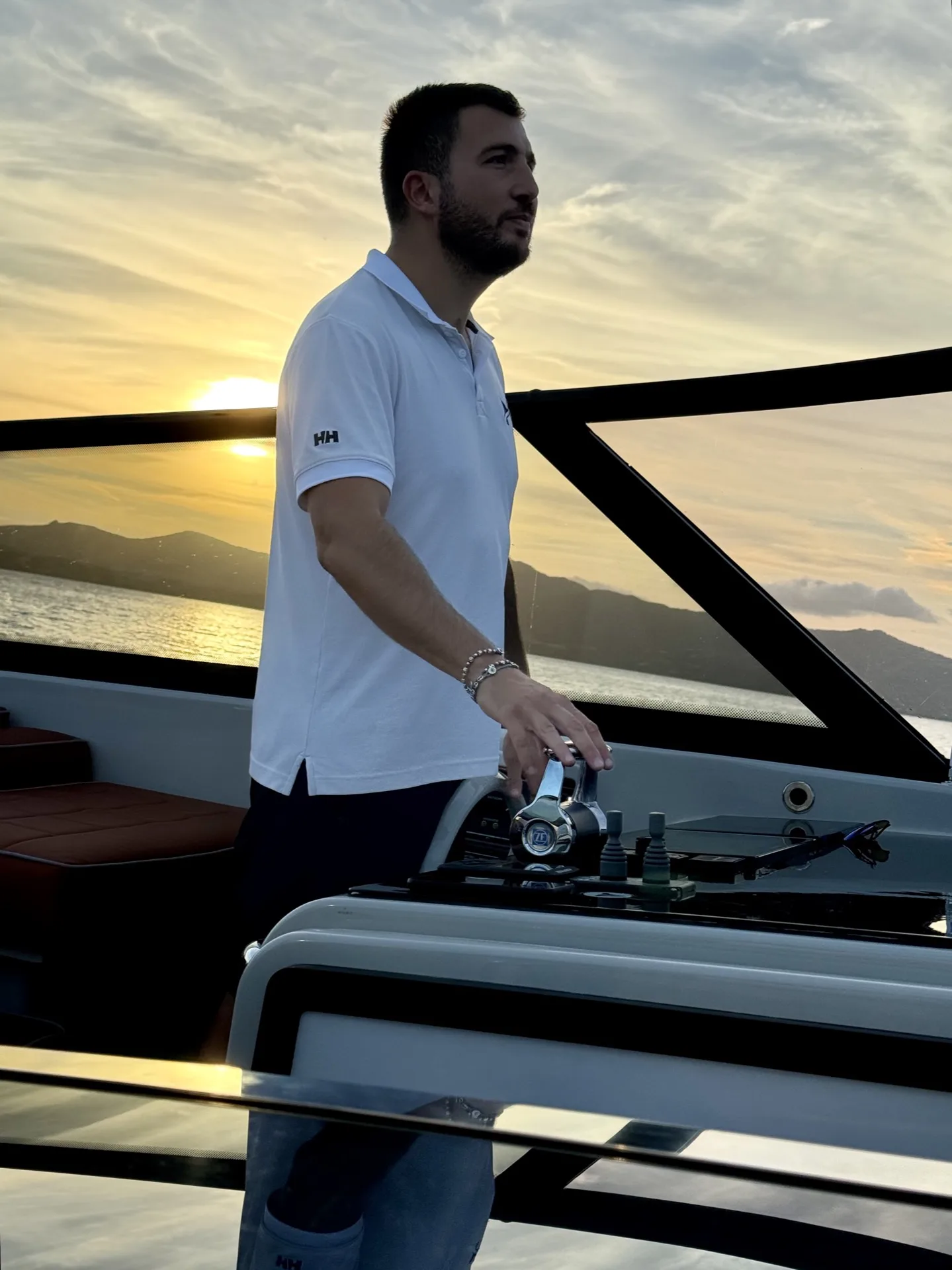 Carlo, MareFun skipper, navigating at the helm during a sunset cruise