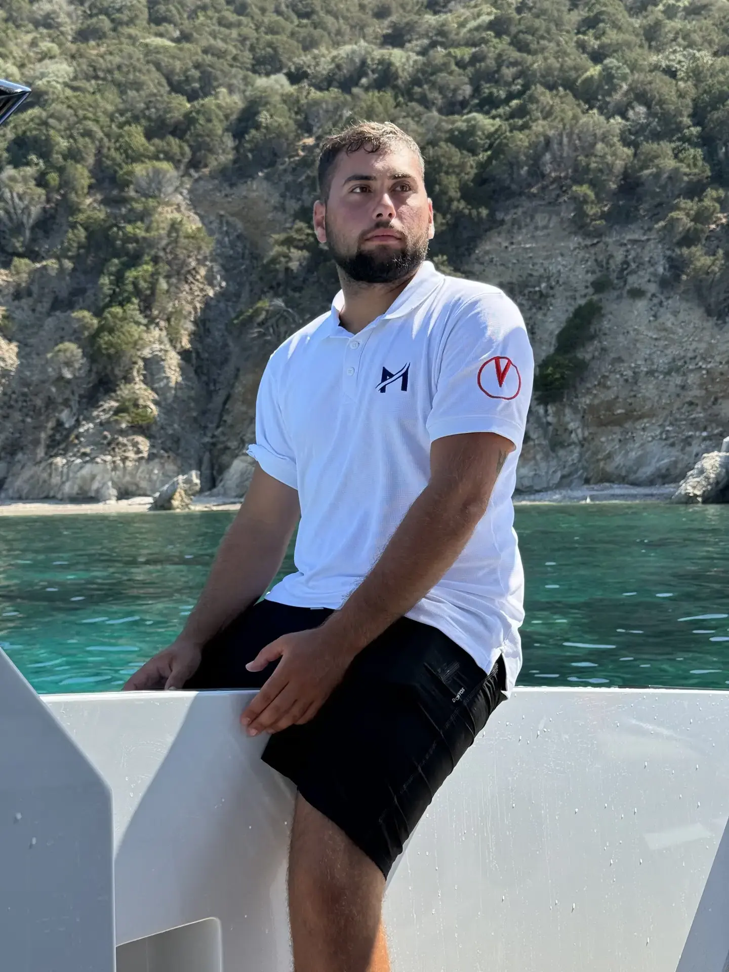 Lorenzo from MareFun on a boat with the Sardinian coast in the background