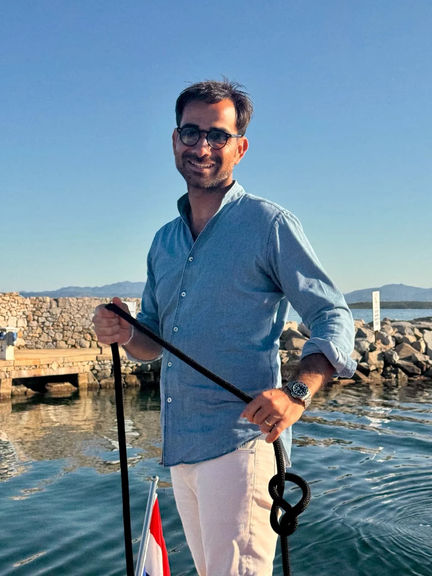 Marco, MareFun founder, standing at the harbour in Golfo Aranci at sunset